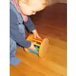GRIMM`S Klingender Babyroller in Regenbogenfarben mit Kind
